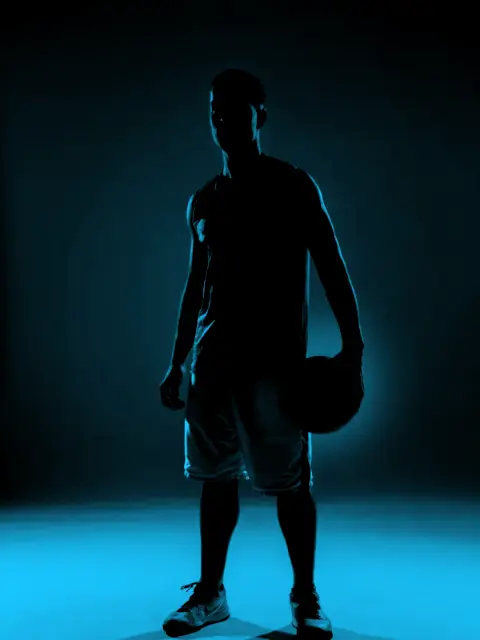 Jugador de básquet a contraluz con el balón